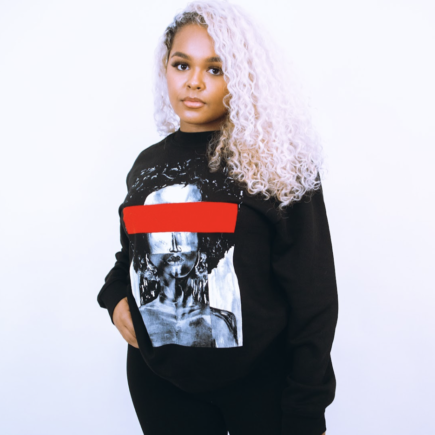 Female wearing Black sweatshirt with monochrome design and red feature