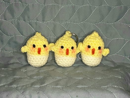 3 crocheted chicks popping out of their eggs