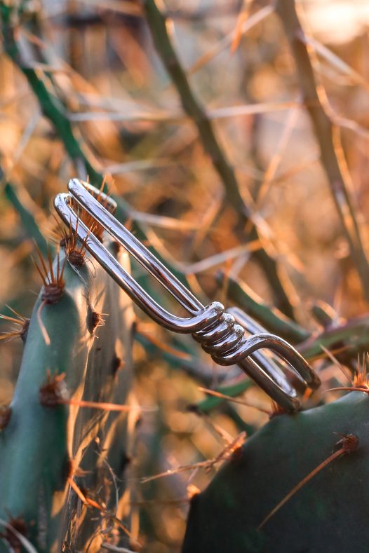 Silver wrap bangle styled against a desert background