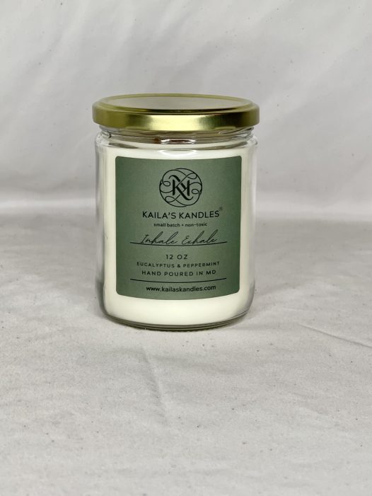 this is a clear glass jar with a gold top. It is filled with fragrant candle wax. The front has a green label with Kaila's Kandles and 12 ounces on it